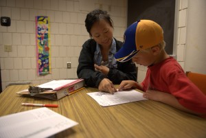UW-Eau Claire psychology major Felicia Som works with seven-year-old Jack Barthen during a Summer Reading Program session.