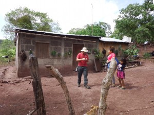 UW-Stout student Trevor Sobtzak, left, takes GPS coordinates outside a home in Las Macias as Marling Garcia, center, and Anyel Garcia watch.