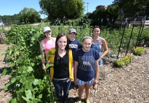 Garden workers take a break. Front row from left, Sarah Rykal, sustainability coordinator, and Brianna Shea. Back row from left, Lyndsey Provos, Laura Donovan and Katie Ankowicz. (UW-Stout photo by Brett T. Roseman)