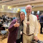 Jessica Stein giving a thumbs up and Matt Aschenbrener of UW-Whitewater standing at the UW System Navigate and Advising Workshop at UW-Stevens Point in March 2023.