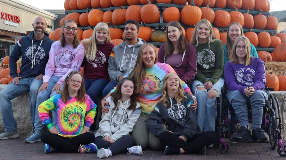 Photo of Sarah Burch, ’10, center, started working with individuals with special needs when she volunteered at Special Olympics while attending UWL. She has created Enrich Each Other Apparel, a clothing line that provides meaningful employment opportunities and job skills training to individuals with disabilities alongside peers without disabilities.