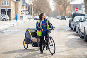 Photo: Delivering by bicycle reduces environmental impact and makes her more approachable, Gianni Vaccaro says. (UWM Photo/Elora Hennessey)