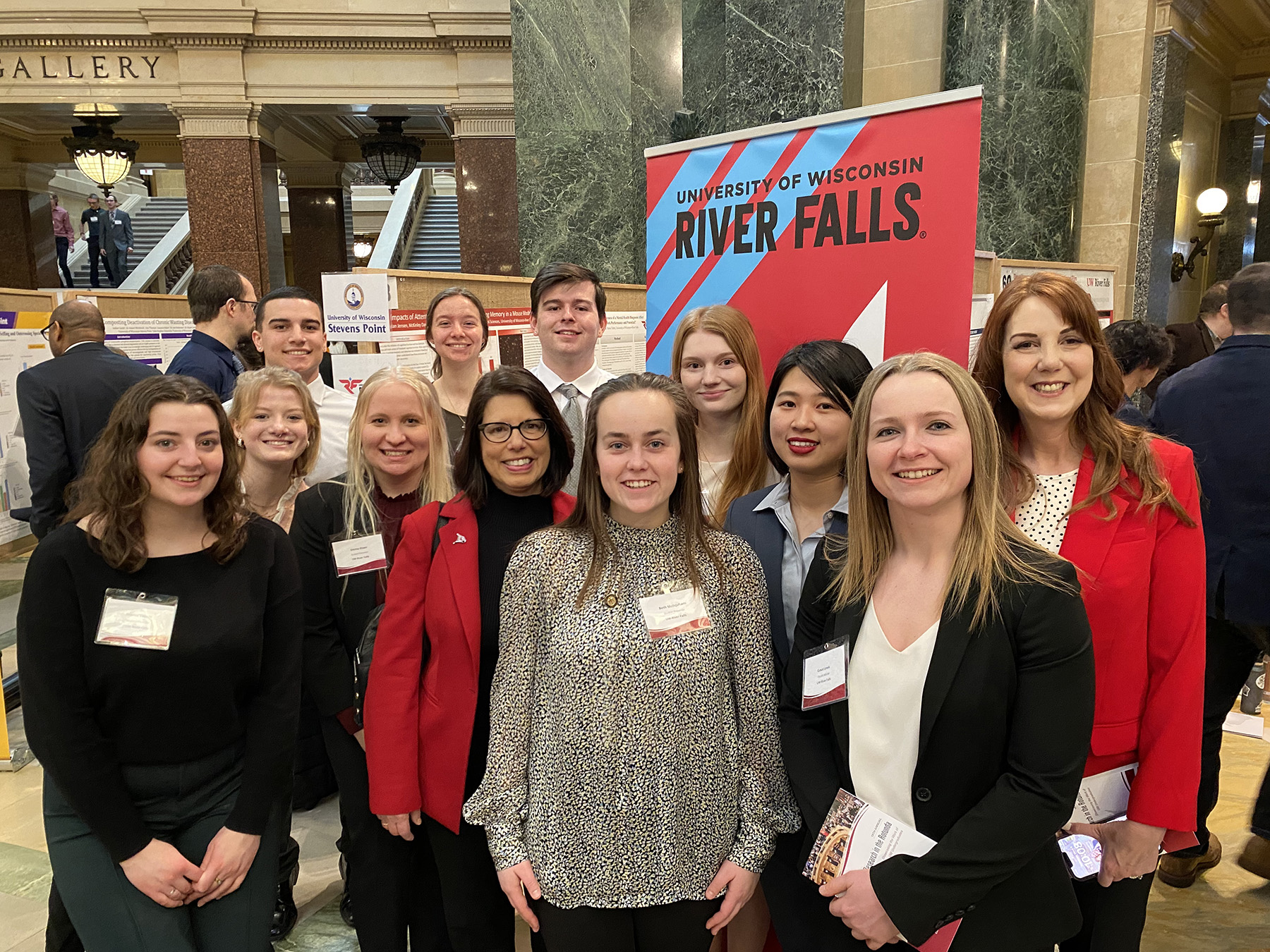 Photo of nine UW-River Falls students who presented their Research in the Rotunda projects at the state Capitol on March 8. Participants and university staff at the event include (back row, left to right) Diego Theisen, Cierra Kirkwood, and Dylan Jensen; (front row, left to right) Sophia Cobian, McKinley Davis, Emma Etten, UWRF Chancellor Maria Gallo, Beth Mcilquham, Sierra Kolodjski, Yihong Deng, Faculty Adviser Grace Lewis, and URSCA Director Molly Gerrish. Beth Schommer/UWRF photo.
