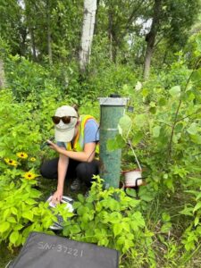 Photo of Bartho, who measured groundwater levels at a permanent in-ground well while shadowing a hydrologist with the Minnesota DNR.