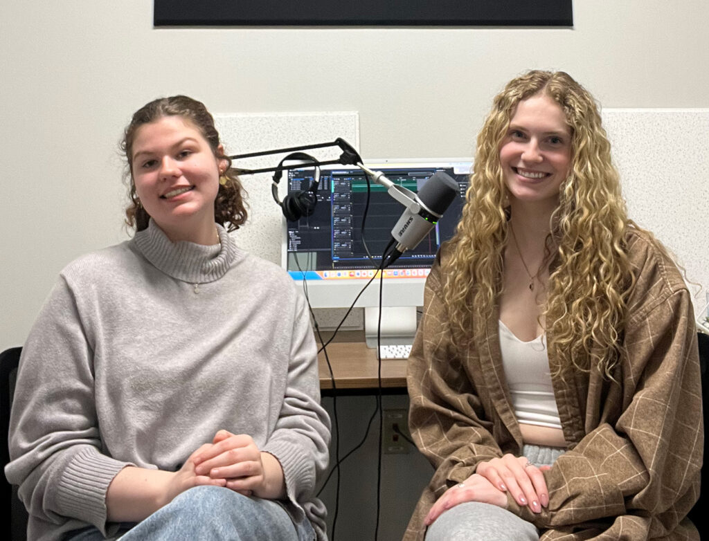 Photo of UW-La Crosse art students Carlyn Farrow and Abby Eftemoff posing for a photo at UWL’s Communication & Media Lab. Both students were part of a ART: 215 "Introduction to Museum Studies" class that developed audio guides for select artworks at the Minnesota Marine Art Museum (MMAM) in Winona. (Courtesy of Sierra Rooney, associate professor of art, UWL)