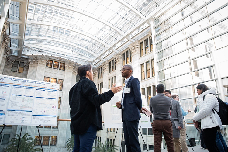 Photo of Ethan Gu, a PhD student in computer science at Marquette University, talking with Onochie Fan-Osuala, an associate professor at UW-Whitewater, at a Northwestern Mutual Data Science Institute event. (Jaclyn Tyler photo)