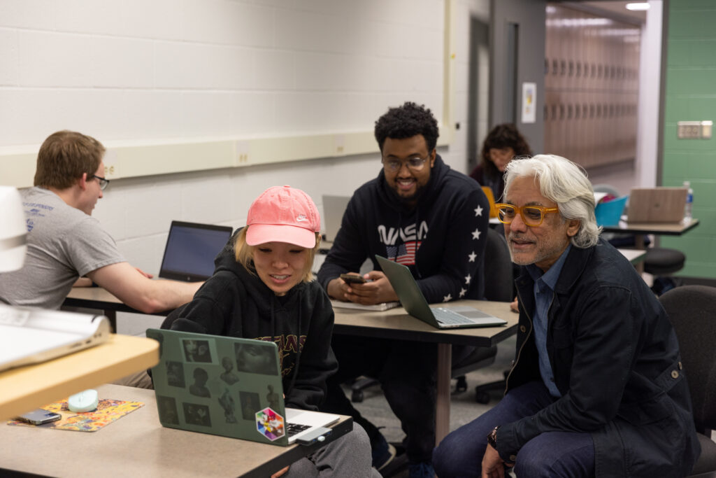 Photo of Professor Nagesh Shinde working with UW-Stout graphic design students. Within Professor Shinde’s Healthcare User Experience Design course, students are working with designers at Epic Systems, who serve as mentors for students as they create web, mobile app or kiosk products and services. / UW-Stout