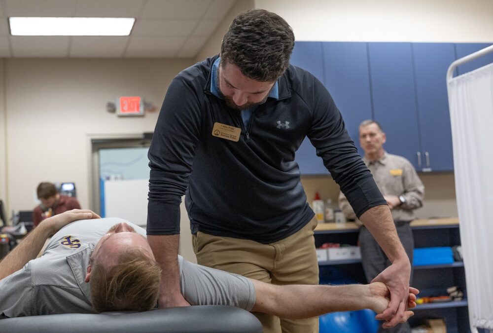 Photo of Caden Prahl, a second-year DPT student, working with a patient at the clinic under the guidance of Clinical Associate Professor Chris Durall. (UW-Stevens Point)