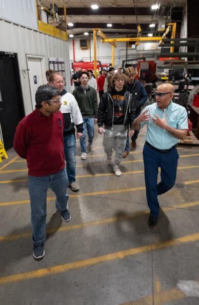 Photo of Muhammad Asim Ali, right, talking to UWO students about operations inside Switchgear Power Systems headquarters in Winneconne.