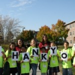 students hold up a sign that says "Thank You"