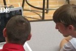 two students looking at a laptop