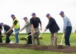 team of people shoveling in a field