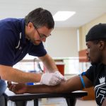 Dr. Matthew Rogatzki draws the blood from the football player prior to a JV game for analysis of biomarkers.