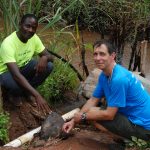 UW-Stout Professor Tom Lacksonen and Hastings Mkwandwire, a resident of Mzuzu, Malawi, observe one of Mkwandwire’s hand-built hydroelectric generators under a metal covering.