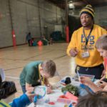 UW-Eau Claire student Ameer Collins, a participant in the Blugold Beginnings Learning Community, works with fifth-grade students from Manz Elementary School in Eau Claire during a citizenship and service event organized by the learning community members.