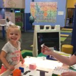 Photo of Clara Wojkiewicz (left) participating in an activity at the Children's Museum of Fond du Lac while UW-Fond du Lac student Grace Hudson monitors her progress.