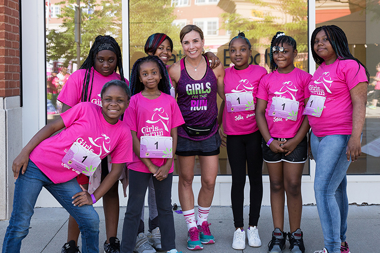 Photo of Tina Jones, executive director of Girls on the Run of Southeastern Wisconsin, standing with some of the kids involved in the program. “What I love about this organization is that we are there to build strong girls and look at the whole girl,” she said. “It’s not just the physical component of things, it’s the emotional component and the social component.” (Photo courtesy of Tina Jones)