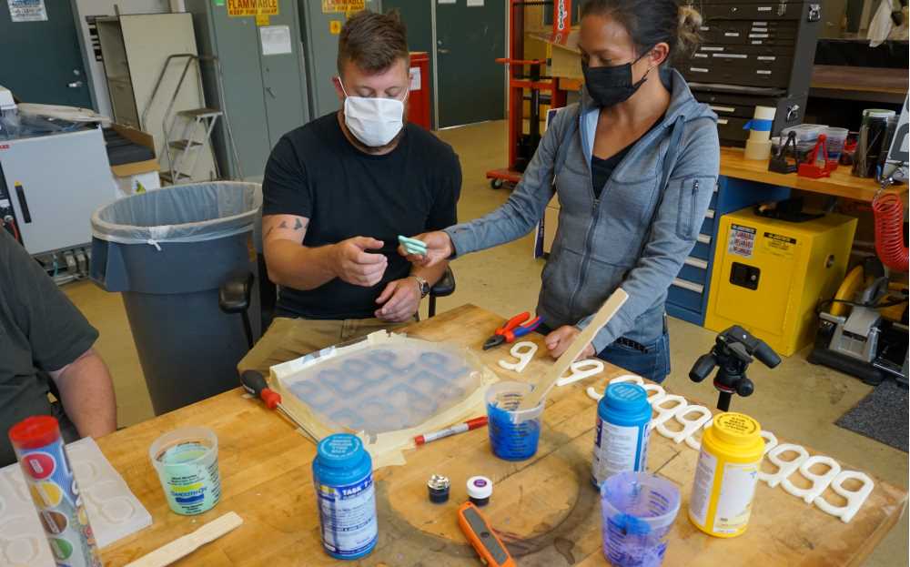 Photo of Zach Heinkel, '18, a composite materials engineer with the Carderock Division of the Naval Surface Warfare Center in Bethesda, Maryland, who is part of a four-person team using 3D printers to produce masks, visors and hands-free door openers for employees at various naval facilities.