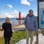 Photo of UW-Milwaukee faculty members Kim Beckmann and John Janssen showing off the results of their joint project, a map of the aquatic ecology of the Milwaukee harbor. A host of environmental agencies are using it to help them make decisions about what restoration projects they will undertake. (UWM Photo/Troye Fox)