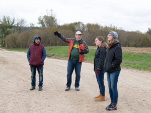 Photo of Dr. Carter Smith talking with students in his community-based Spanish language class during a visit to a nearby farm that employs migrant workers.