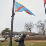 Photo of UWL Senior Vanessa Mbuyi Kaja raising the flag of the Democratic Republic of Congo for the first time on campus during a December 2020 ceremony. “I already knew I was accepted here in La Crosse, but this makes me feel like yes, I can call this my home,” noted the microbiology major.