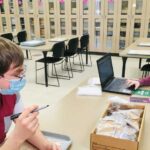 Photo of UWL students Miles Martinez, left, and Lauren Brewer documenting archaeological materials in the UWL Archaeology Lab during the spring 2021 semester.