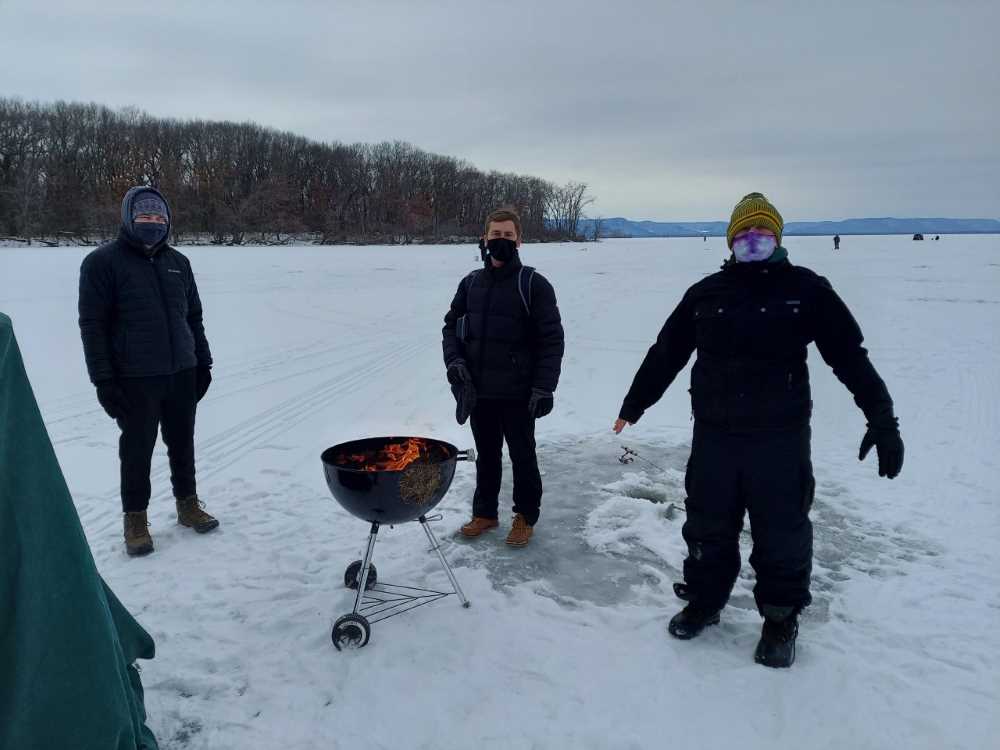 Photo of UW-La Crosse Sigma Tau Gamma members, from left, Ryan Langemak, Cade Jallo, and Mike Weisse, taking a break from fishing to grill some food. The three, and five others, participated in the group’s first Ice-Fish-A-Thon to raise money for Special Olympics when the in-person Polar Plunge event was altered due to the pandemic.