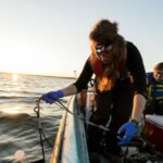 Photo of students collecting data and water samples from Lake Mendota during an early morning outing in 2016 for a limnology experiment. Limnology researchers discovered the spiny water flea in Lake Mendota in 2009. PHOTO: JEFF MILLER