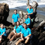 Photo of winners of the 2014 Lake Sturgeon Bowl, the Spring Valley High School team from Wisconsin, sitting on a huge piece of driftwood at Rialto Beach on the Pacific Ocean in Washington before competing in the National Ocean Sciences Bowl in Seattle. (Submitted photo)