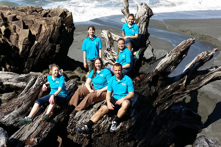 Photo of winners of the 2014 Lake Sturgeon Bowl, the Spring Valley High School team from Wisconsin, sitting on a huge piece of driftwood at Rialto Beach on the Pacific Ocean in Washington before competing in the National Ocean Sciences Bowl in Seattle. (Submitted photo)