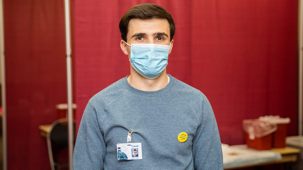 Photo of Travis Clary, who is interning at the Grant County Health Department, assisting at the vaccination clinics on campus.