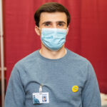 Photo of Travis Clary, who is interning at the Grant County Health Department, assisting at the vaccination clinics on campus.