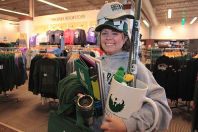 Photo of Alumni Director Kari Moody loads-up on Phoenix pride items from The Phoenix Bookstore.