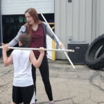 Photo of Kinesiology senior Brianna Roberts as an intern at Sports AdvantEdge in Verona working with young athletes.