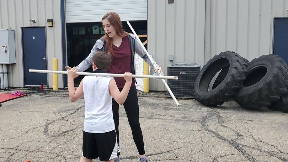 Photo of Kinesiology senior Brianna Roberts as an intern at Sports AdvantEdge in Verona working with young athletes.