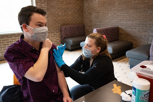 Photo of UW-Stevens Point student Nicholas Tierman receiving his COVID-19 vaccine from Hanna Christensen, one of several UWSP nursing students who are assisting with COVID-19 care and vaccination this spring.