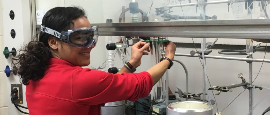 Photo of Jordan Munos, who as a member of the student research team in the chemistry lab with Dr. James Phillips, found her passion for biomedical research. She is pictured here installing a liquid nitrogen trap on the preparatory vacuum line, just one of many complex instruments Blugold researchers like Munos learn to master.