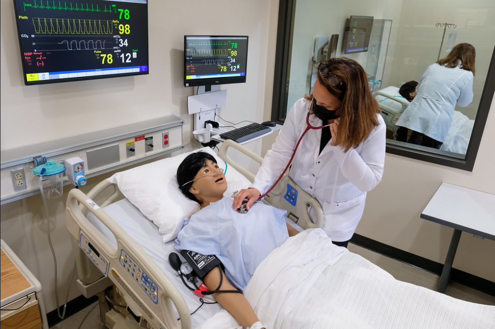 Photo of a nursing instructor training on the new hi-tech human patient simulator inside the Aurora BayCare Nursing Skills Center on the UW-Green Bay Campus. These manikins offer nursing students with realistic patient healthcare scenarios for critical thinking and clinical skills training. UW-Green Bay's partnership with Aurora BayCare ensures our nursing students are prepared to deliver high-quality, safe patient care as they prepare for their clinical courses.