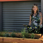 Photo of Carrie Bristoll-Groll showing off StormGUARDen, a product her company launched that serves as a combination rain garden and rain barrel. (Photo courtesy of Carrie Bristoll-Groll)