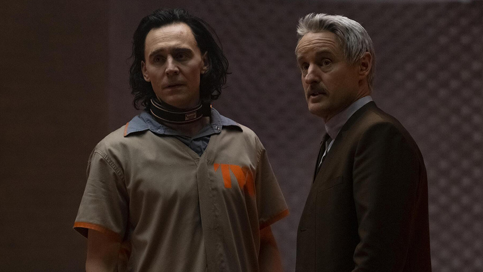 Photo of scene from new Marvel series, Loki, featuring actor Owen Wilson (right) playing Mobius, made to physically resemble UW Oshkosh alum Mark Gruenwald, who had a storied career with Marvel Comics until his unexpected death in 1996.