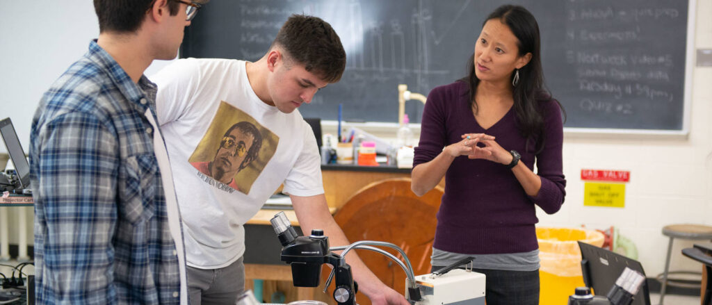 Photo of Dr. Nora Mitchell, UW-Eau Claire assistant professor of biology, who will direct a workshop for Upward Bound students on using the supercomputing cluster to build evolutionary trees to understand relationships among species. Mitchell is shown in this photo working with UW-Eau Claire students in a biology class lab. (Photo by Shane Opatz)