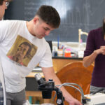 Photo of Dr. Nora Mitchell, UW-Eau Claire assistant professor of biology, who will direct a workshop for Upward Bound students on using the supercomputing cluster to build evolutionary trees to understand relationships among species. Mitchell is shown in this photo working with UW-Eau Claire students in a biology class lab. (Photo by Shane Opatz)