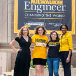 Photo of Bryn Glennon (left) and Mara Charpentier (third from left), who are two of the first three UWM graduates from the PECS program, which aims to boost the number of students from underrepresented groups who become engineers and computer scientists. With them are Wilkistar Otieno (right), associate professor of engineering, and Christine Beimborn, STEM outreach specialist in engineering. (UWM Photo/Elora Hennessey)