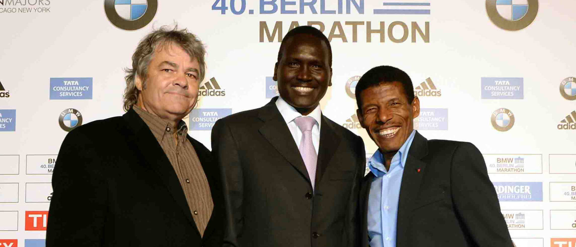 Photo of Dr. Sean Hartnett, UW-Eau Claire professor of geography, standing with marathoners Paul Tergat, center, and Haile Gebrselassie at a 2011 celebration of world record holders at the 2011 Berlin Marathon.