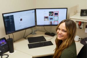 Photo of UWL graduate Paige Ford in front of computer screens. By giving Kwik Trip’s social media accounts a new and engaging voice, Forde has helped grow the company’s following on Facebook (600,000 likes), Instagram (88,000 followers), TikTok (76,000 followers) and Twitter (67,000 followers).