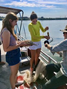 Photo of Jake Vander Zanden helping students in their first-ever “Freshwater 101” course take a water sample during a fall field trip. Photo: Adam Hinterthuer