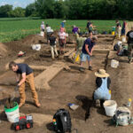 Photo of field school students excavating a patch of farm field to expose pit and post hole features at the Koshkonong Creek Village site. (Photo courtesy of the Anthropology Department)