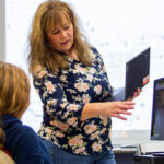 Photo of Jessica Brogley works with a student.