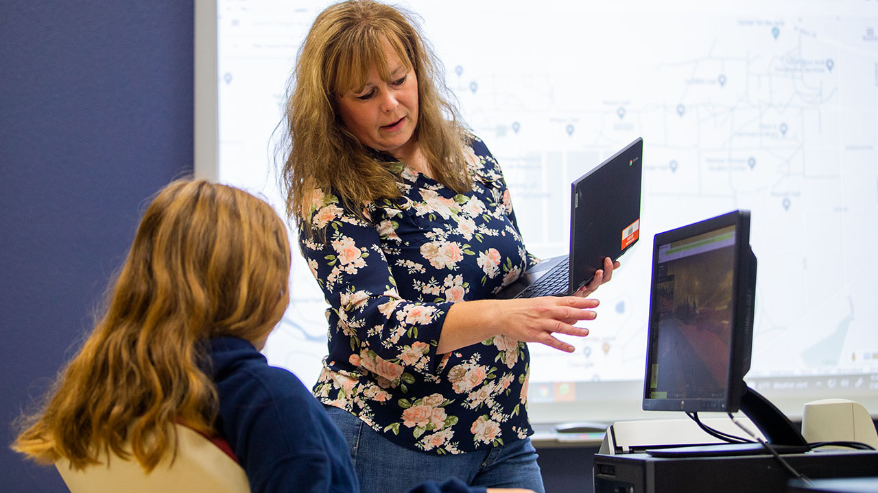 Photo of Jessica Brogley works with a student.