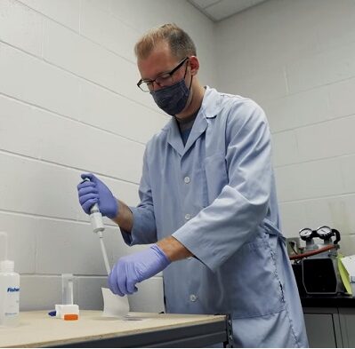 Photo of Alex Thomas, a graduate assistant at UW-Stevens Point, working on his graduate thesis through the CWD composting project.